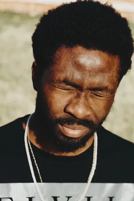 Portrait d'un homme noir fermant les yeux.